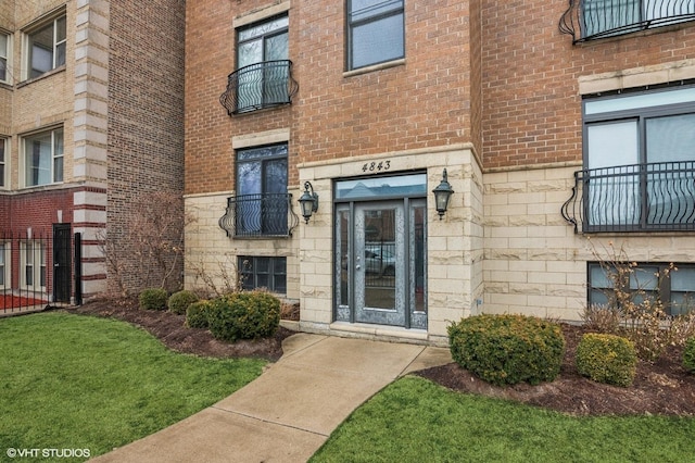 view of exterior entry featuring stone siding and brick siding