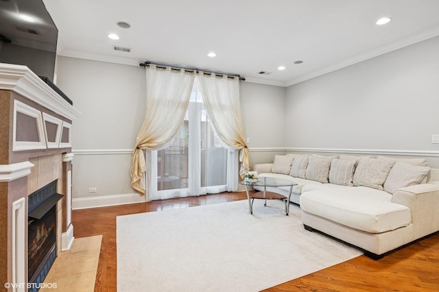 living room featuring visible vents, a tile fireplace, ornamental molding, wood finished floors, and recessed lighting