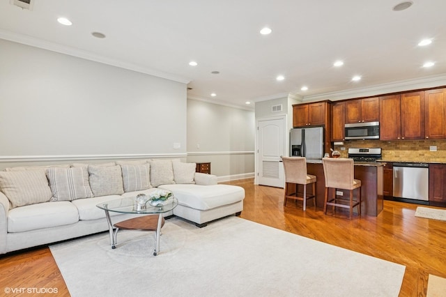 living room featuring light wood-style floors, visible vents, and recessed lighting