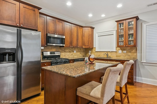 kitchen featuring stainless steel appliances, visible vents, a sink, and crown molding