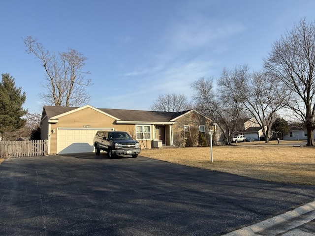 ranch-style house with driveway, an attached garage, and fence