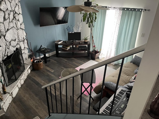 living room featuring baseboards, ceiling fan, stairway, wood finished floors, and a fireplace