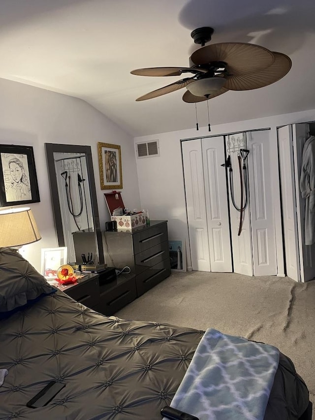 carpeted bedroom featuring lofted ceiling, ceiling fan, and visible vents