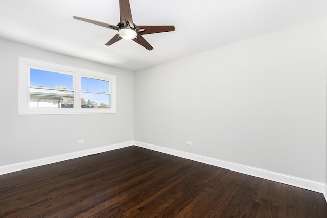 spare room with ceiling fan, baseboards, and dark wood-type flooring