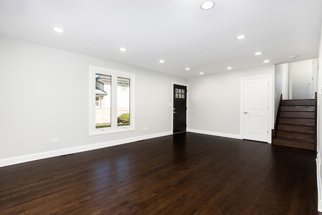 empty room with stairs, dark wood-style flooring, baseboards, and recessed lighting