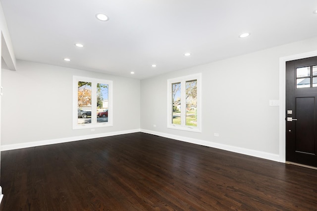 unfurnished living room featuring baseboards, dark wood finished floors, and recessed lighting