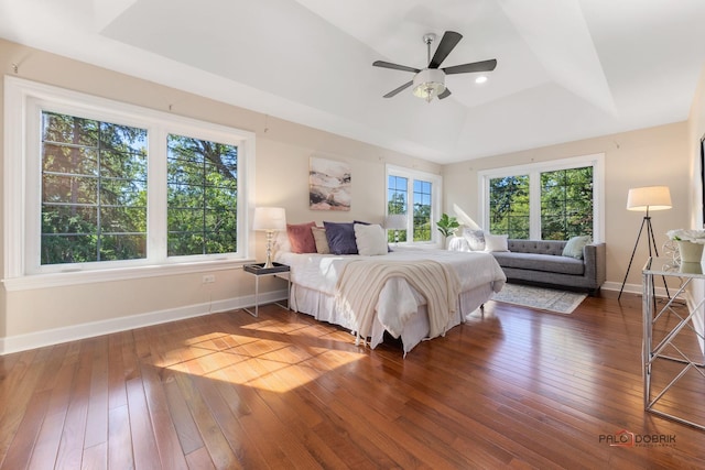 bedroom with recessed lighting, a ceiling fan, baseboards, a tray ceiling, and wood-type flooring