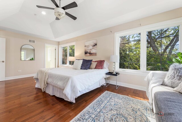 bedroom with vaulted ceiling, wood-type flooring, visible vents, and baseboards