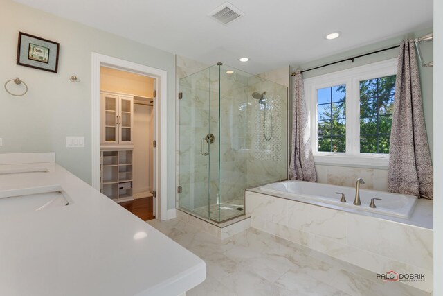 bathroom featuring a stall shower, visible vents, marble finish floor, a walk in closet, and a sink