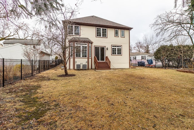 rear view of house with entry steps, a fenced backyard, a yard, and central air condition unit