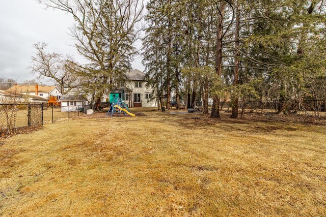 view of yard featuring a fenced backyard and a playground