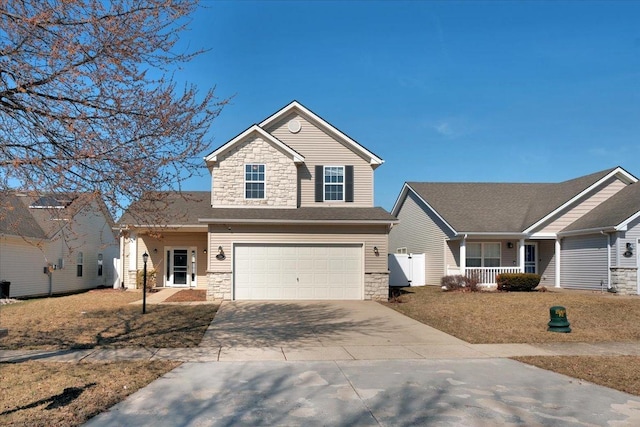 view of front facade with a porch, an attached garage, stone siding, and driveway