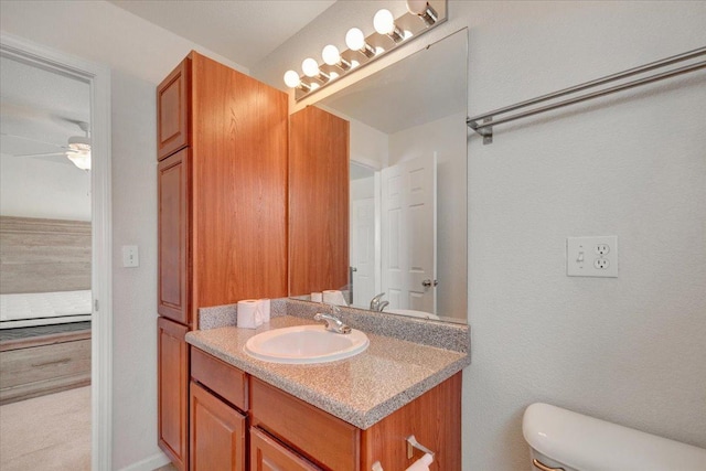 half bathroom featuring toilet, vanity, and a ceiling fan