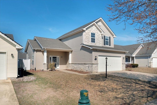 view of front of home with driveway, a shingled roof, a front lawn, a garage, and stone siding