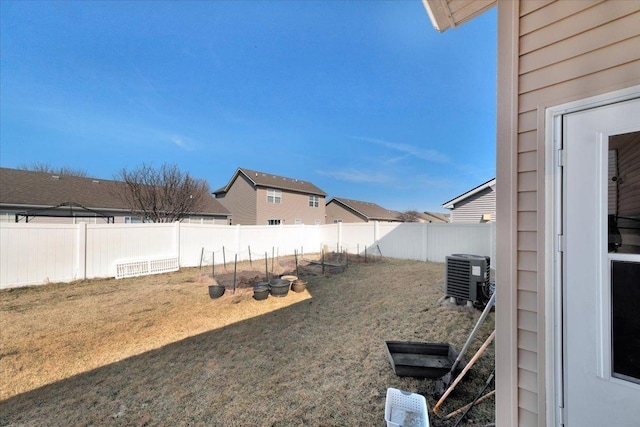 view of yard with a fenced backyard and central AC