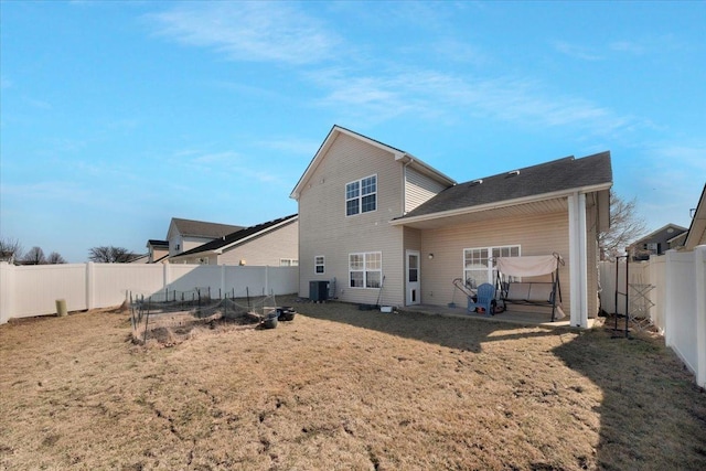 back of property featuring a lawn, a fenced backyard, a vegetable garden, central AC unit, and a patio area