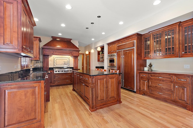 kitchen with stainless steel appliances, a sink, light wood-type flooring, custom exhaust hood, and a center island