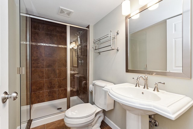 bathroom with a stall shower, visible vents, a sink, and toilet