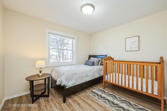 bedroom featuring wood finished floors and baseboards