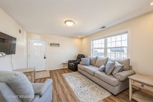 living area featuring recessed lighting, visible vents, baseboards, and wood finished floors