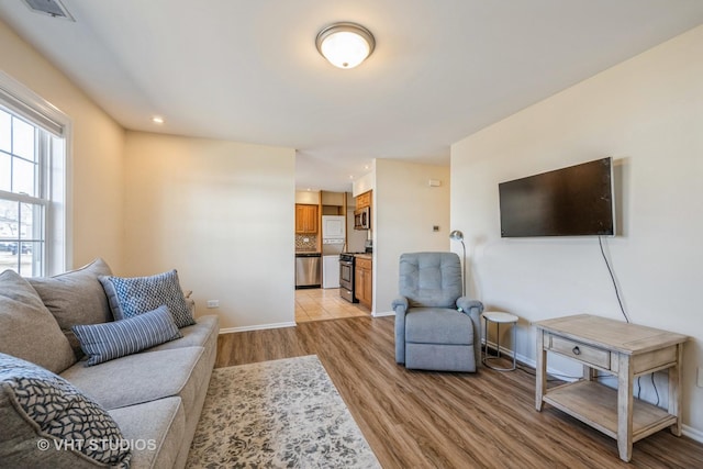 living area featuring recessed lighting, visible vents, light wood-style flooring, and baseboards