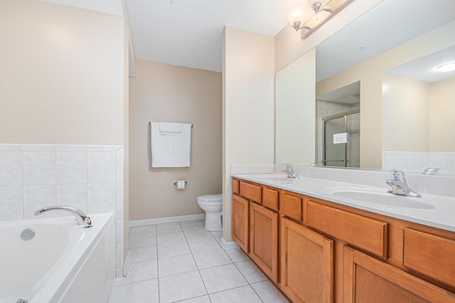 full bathroom with a garden tub, a stall shower, tile patterned flooring, and a sink