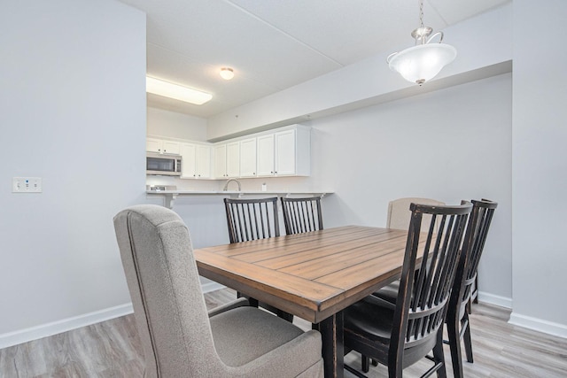 dining room with light wood finished floors and baseboards