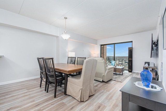 dining area with light wood-style floors and baseboards