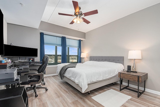 bedroom with light wood-style floors, ceiling fan, and baseboards