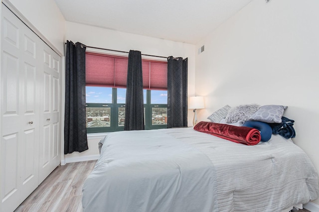 bedroom featuring a closet, wood finished floors, and visible vents