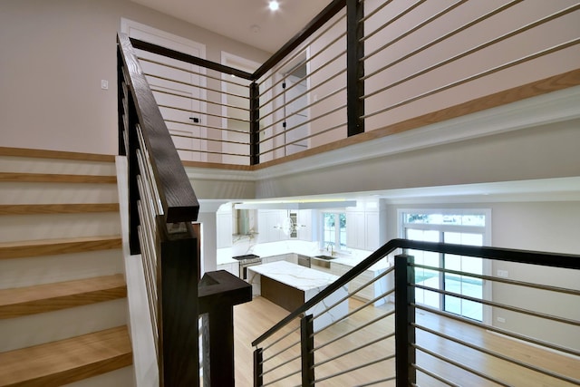 staircase with a high ceiling and wood finished floors