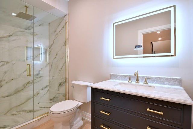 full bathroom featuring baseboards, toilet, vanity, and a marble finish shower