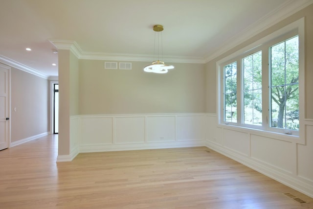 unfurnished room with an inviting chandelier, light wood-type flooring, visible vents, and crown molding