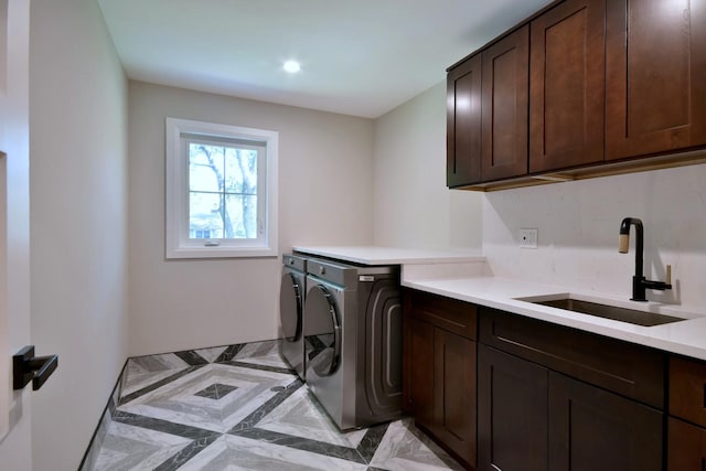 washroom with cabinet space, a sink, and washing machine and clothes dryer