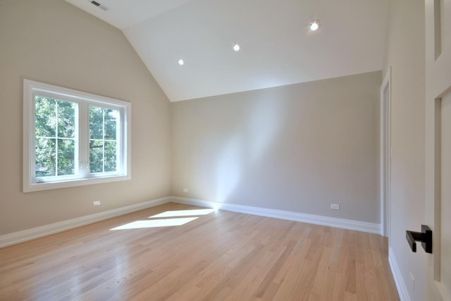 unfurnished room with light wood-style flooring, baseboards, and vaulted ceiling