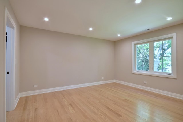 spare room featuring light wood-type flooring, visible vents, baseboards, and recessed lighting