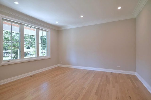 empty room with ornamental molding, light wood-type flooring, baseboards, and recessed lighting