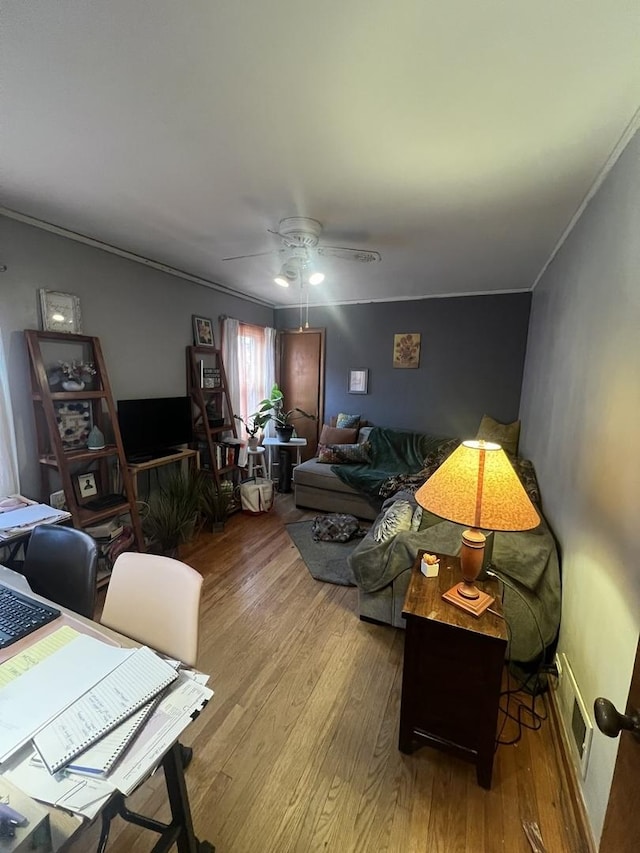 living room featuring ceiling fan, crown molding, and wood finished floors