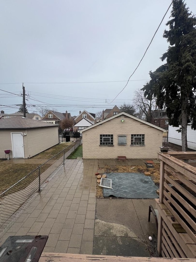 view of side of property featuring a patio area, fence, and brick siding