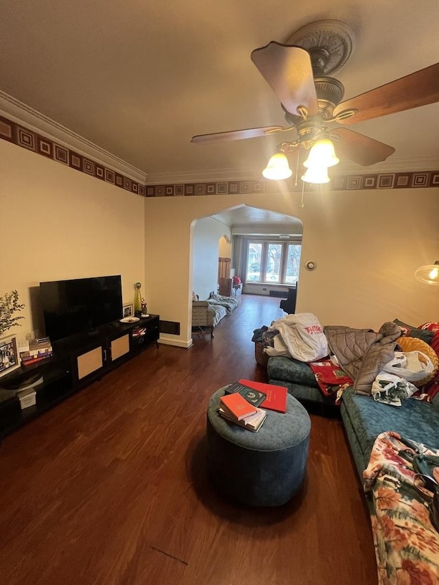 living area featuring a ceiling fan, crown molding, arched walkways, and wood finished floors