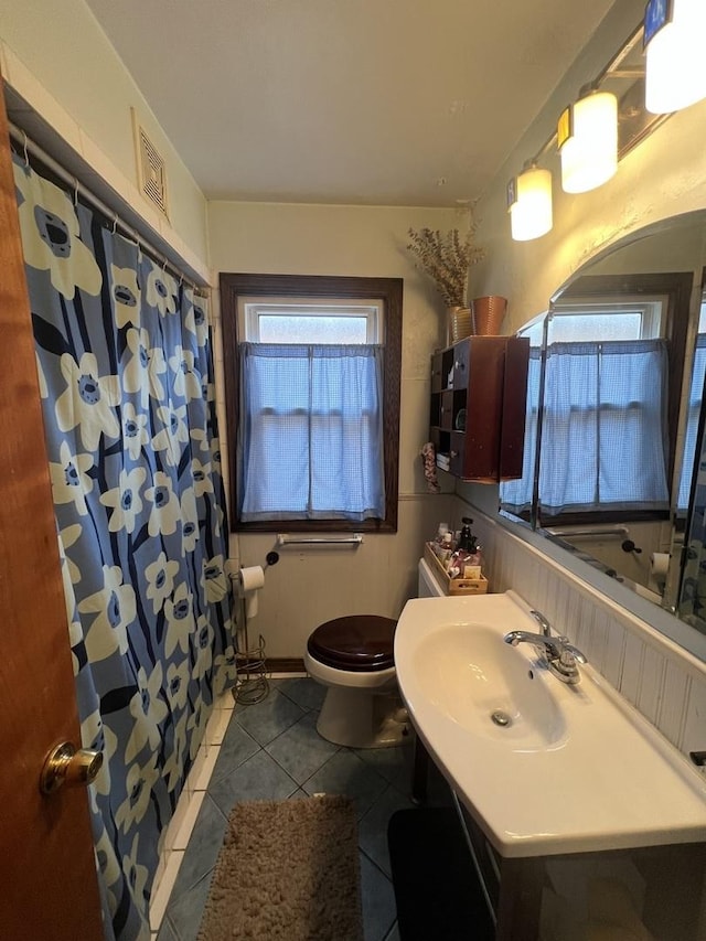 full bath with a shower with curtain, vanity, toilet, and tile patterned floors