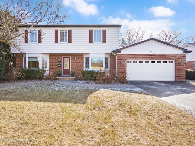 colonial inspired home featuring a garage, driveway, brick siding, and a front yard