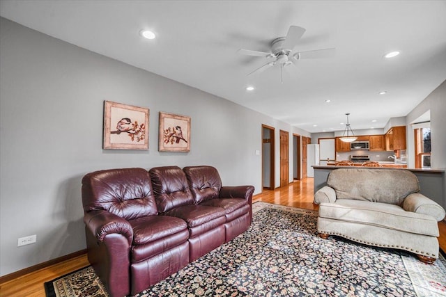 living area featuring recessed lighting, baseboards, light wood-style floors, and a ceiling fan