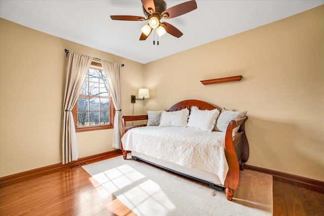 bedroom featuring visible vents, wood finished floors, baseboards, and ceiling fan