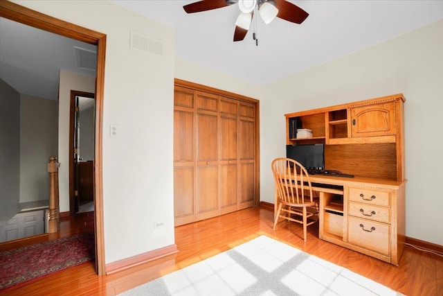 office space featuring light wood-type flooring, visible vents, baseboards, and a ceiling fan