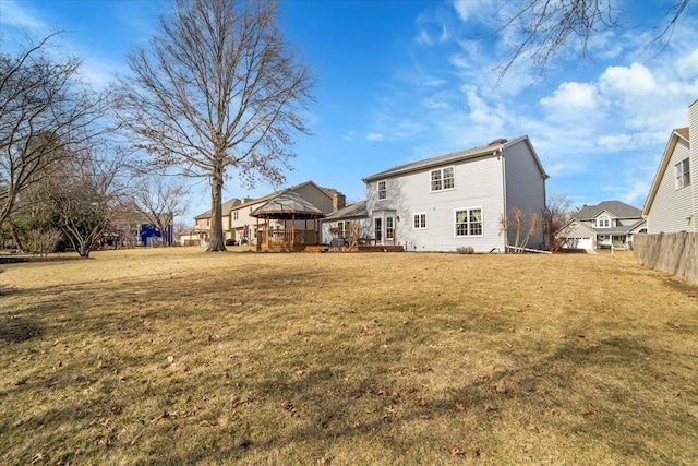 rear view of property with a lawn, a deck, and fence