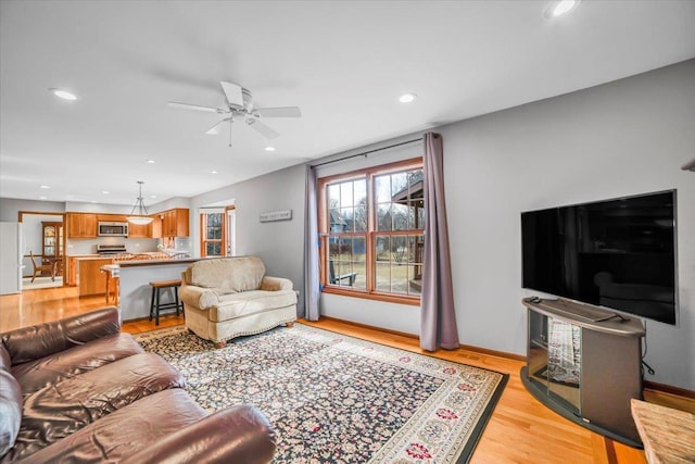 living room featuring recessed lighting, baseboards, light wood-style floors, and ceiling fan