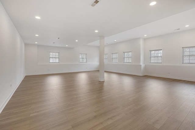 empty room with baseboards, light wood-type flooring, visible vents, and recessed lighting