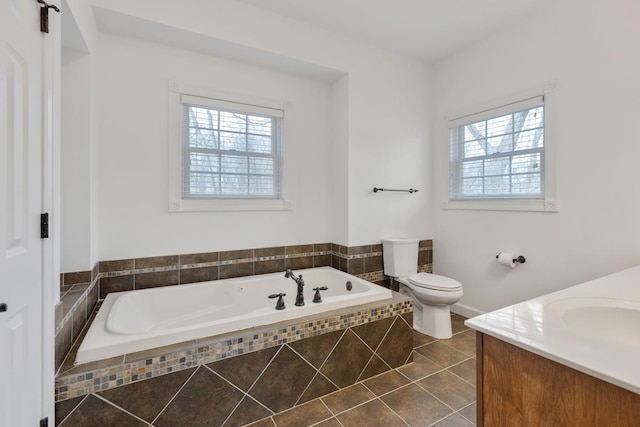 bathroom featuring toilet, tile patterned flooring, a bath, and vanity