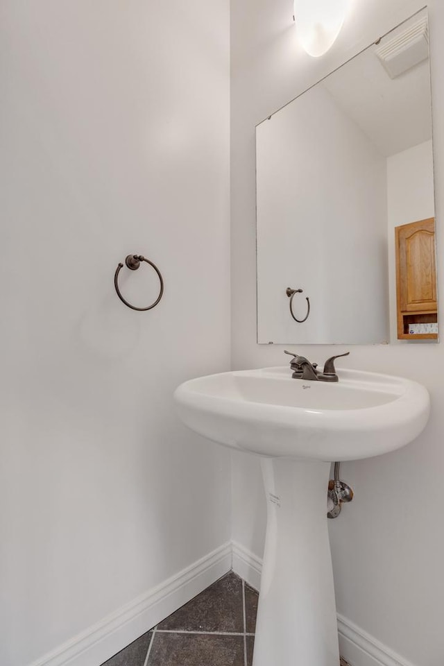 bathroom with a sink, baseboards, and tile patterned floors